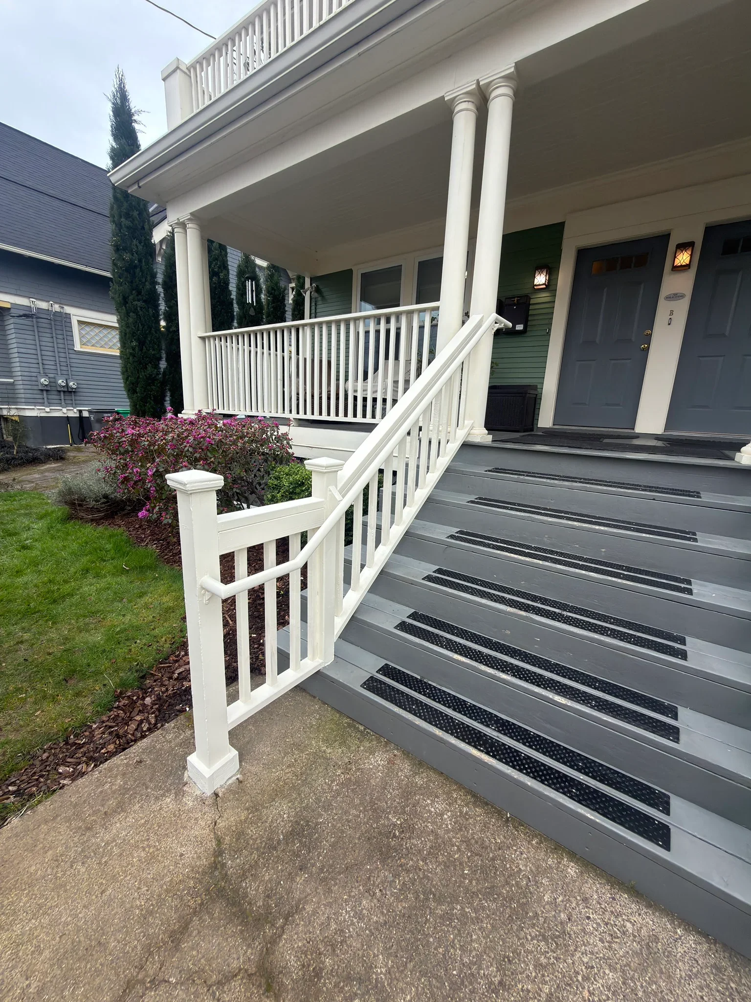 White railing and gray composite stairs with anti-slip treads on residential front porch