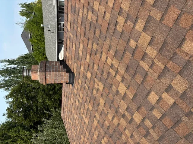 Newly installed brown architectural shingles on residential roof with diamond pattern layout