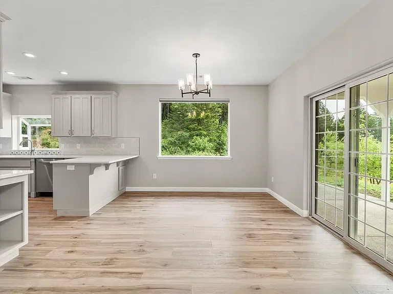 Bright open concept kitchen and living room with hardwood floors and glass doors